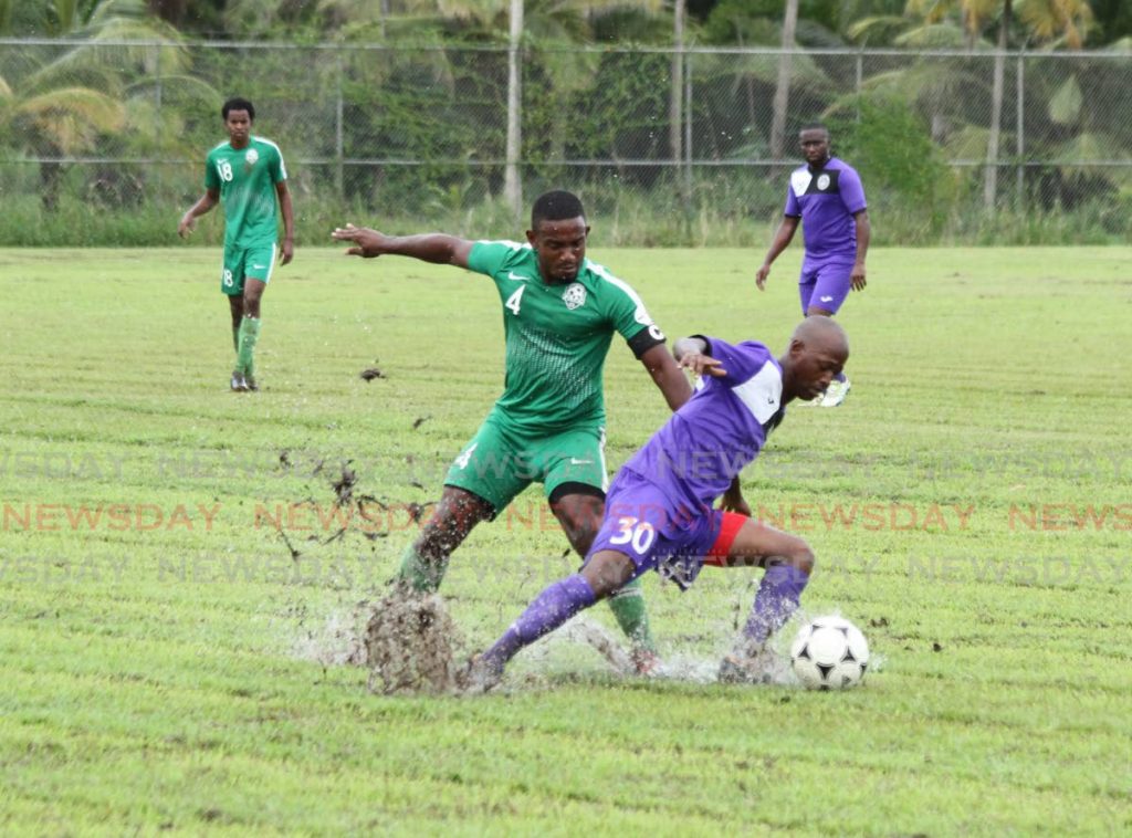 Prisons FC’s Anthony Parris (L) and Police FC’s Orlando Reyes vie for the ball during the Super League match, at the Youth Training Centre grounds, Arouca,on Sunday. - AYANNA KINSALE