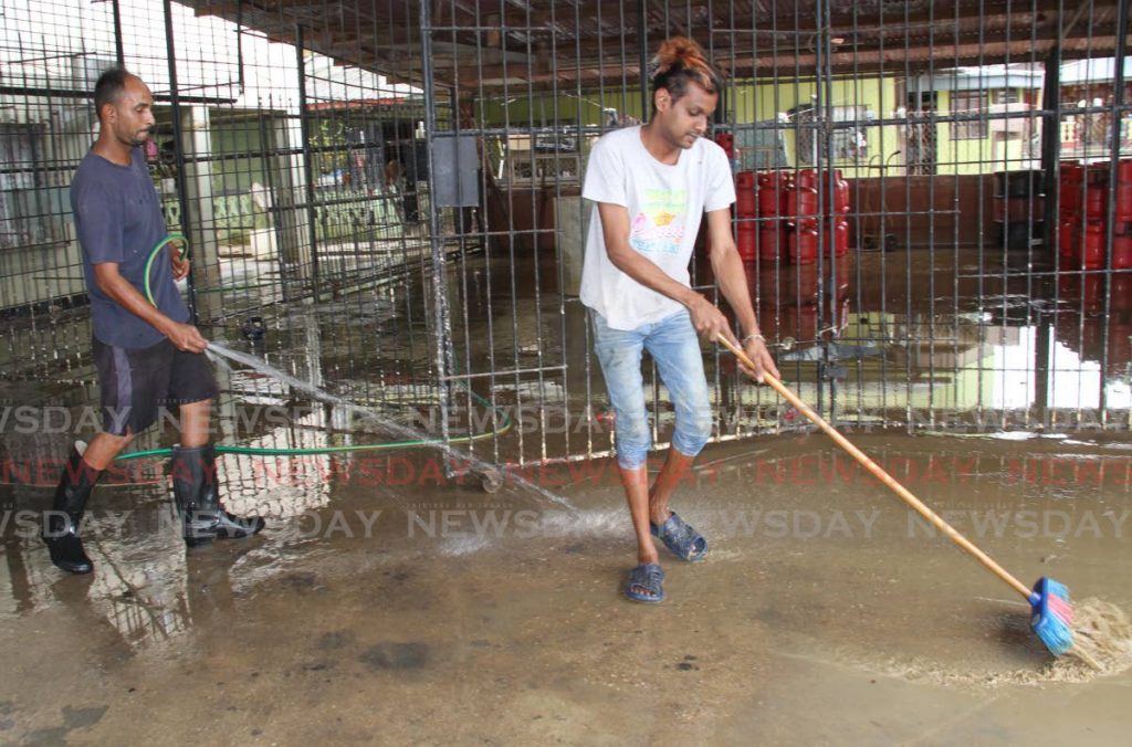 Sullyman Baig, left, and Saied Baig clean their businessplace at La Fortune, Woodland, on Sunday. - Vashti Singh