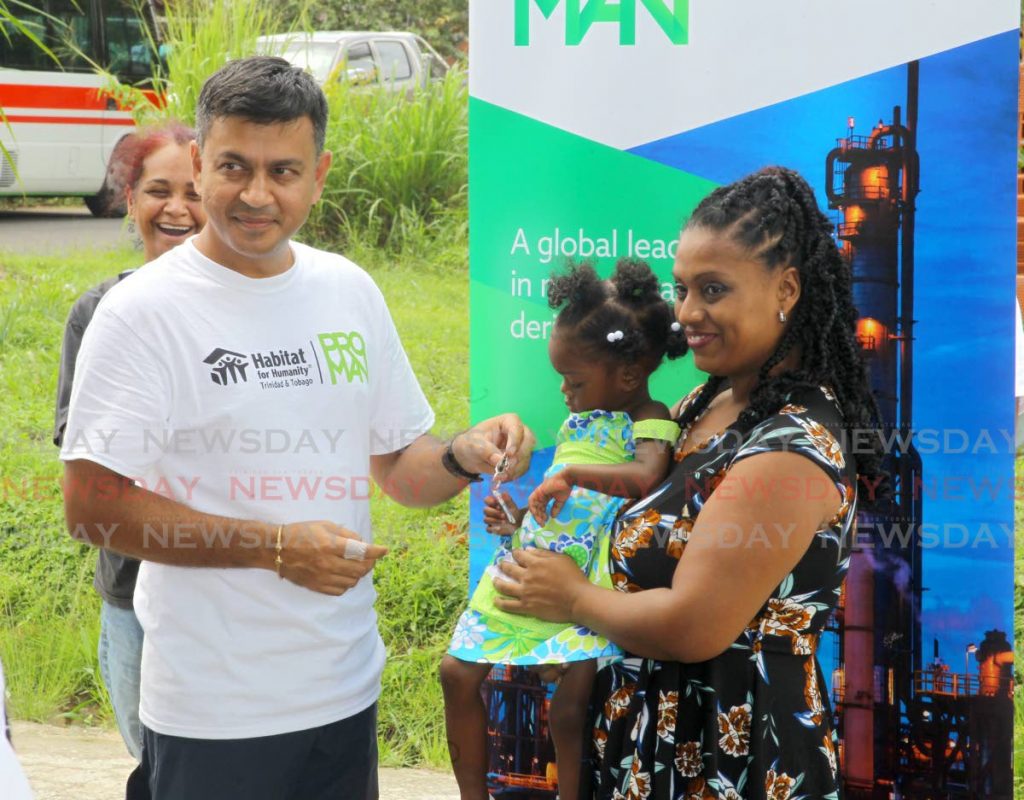 BEAMING: Hannah D'Abreau receives her keys from Proman Trinidad's Rishen Doolcharan Proman Trinidad at a dedication and hand-over ceremony in collaboration with Habitat for Humanity TT at KP Lands Valencia last week. - ROGER JACOB