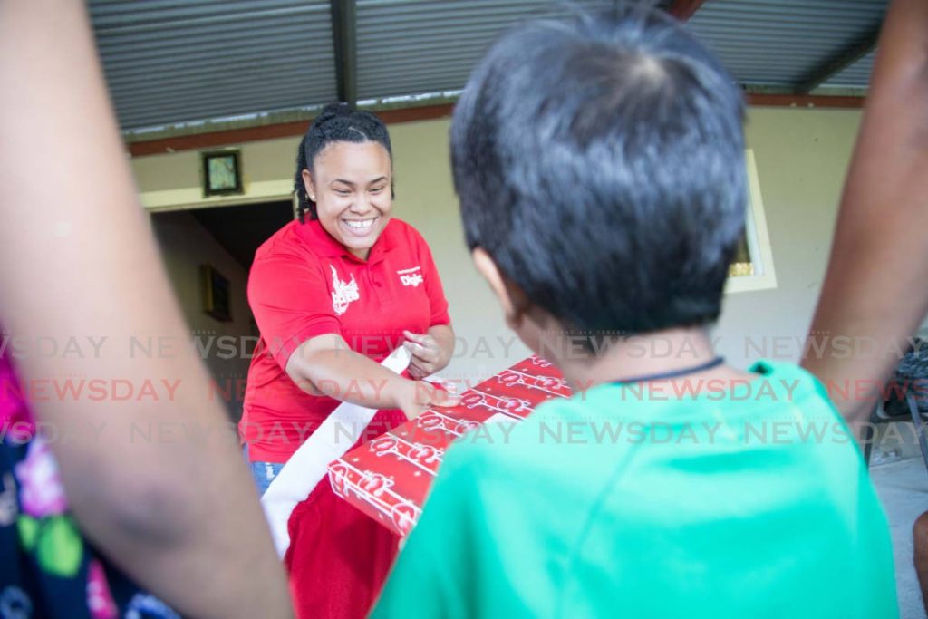  Digicel Foundation project manager Lynelle Callender brings Christmas cheer and presents for a family in need. - 