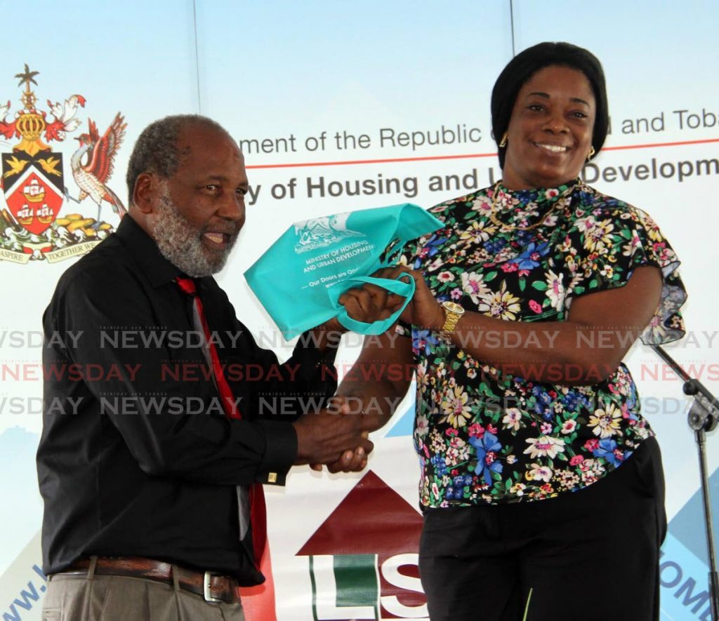 Land Settlement Agency Chairman Ossley Francis presents Nikesha London with keys to a new starter home at Third Indian Walk Baptist Church, Moruga on Friday. - Vashti Singh