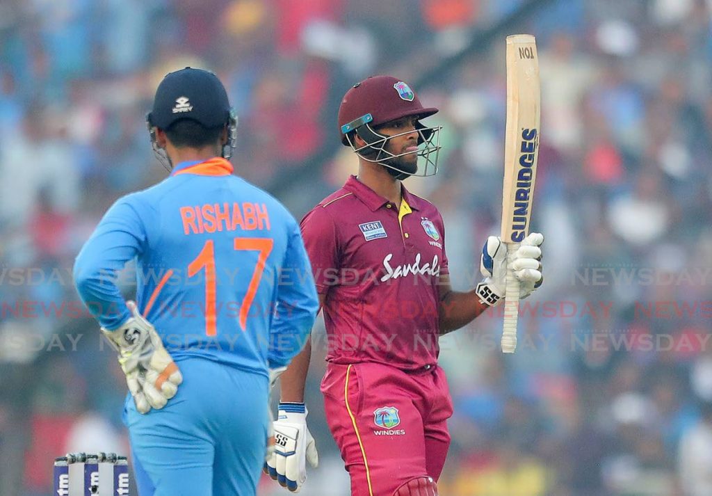 West Indies’ Nicholas Pooran raises his bat to celebrate scoring fifty runs during the third and final one-day of the series between India and West Indies in Cuttack, India, on Sunday. AP Photos - 