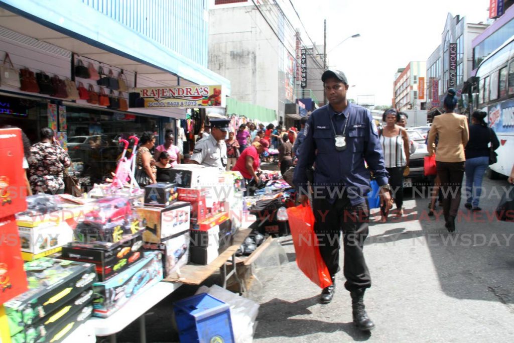 A police officer is seen shopping on High Street , San Fernando. Photo by - Vashti Singh