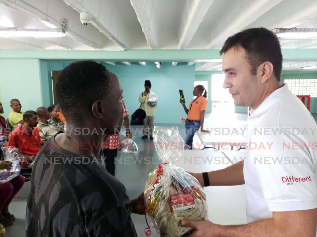 A resident at the Centre for Socially Displaced receives a hamper from Jabbor Kayumov, Digicel CEO. - 