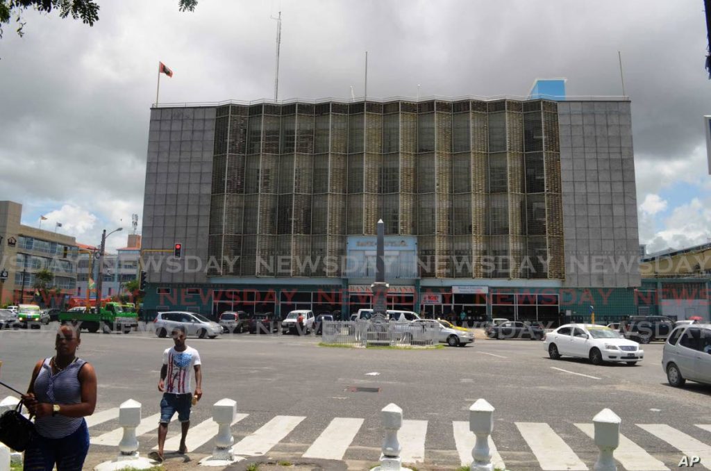 People walk near the central bank in Georgetown, Guyana, where the discovery of major oil and gas deposits offshore in the Atlantic have ignited hope that the country would undergo economic transformation. Photo taken from voanews.com - 