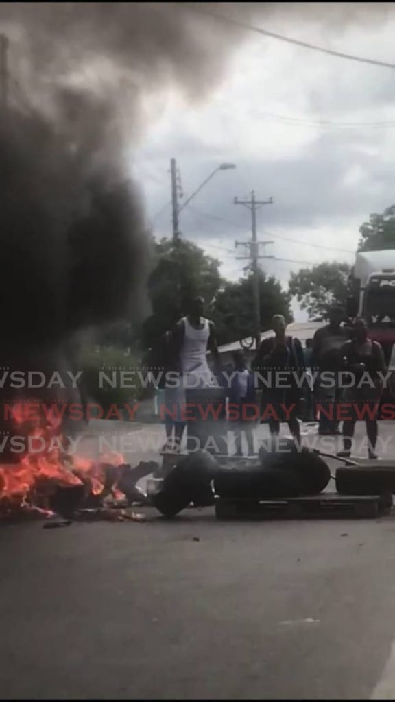 Parents and residents block the road with burning debris to highlight issues affecting the Claxton Bay Junior Anglican school.  - 