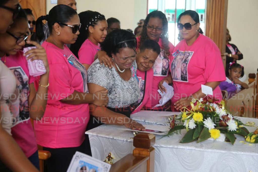 Relatives console each other during the funeral of murder victims Polly Ann and Damian Chuniesingh at the Santa Rosa RC Church on Saturday, in Arima.  - Sureash Cholai