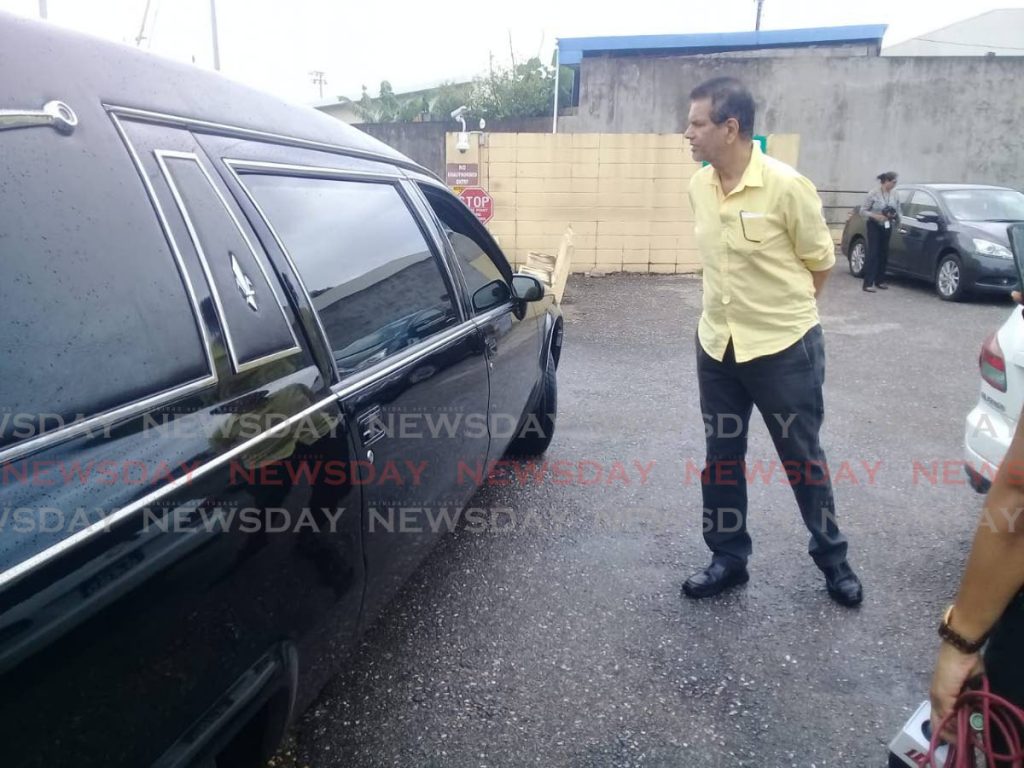 Chandresh Sharma, former MP for Fyzabad, speaks to the driver of the hearse carrying his nephew Dr Rudradeva Sharma at the Forensic Science centre in St James on Wednesday.   - SHANE SUPERVILLE
