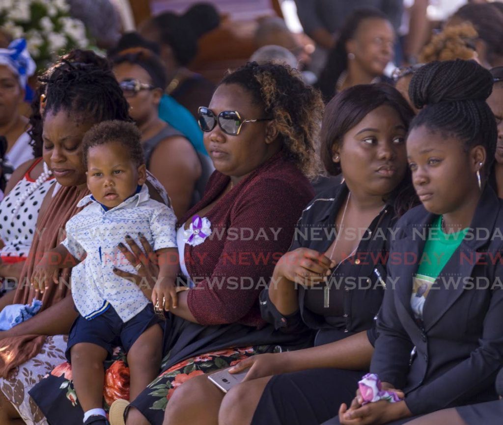 Widow of murdered security officer Mark Nurse, Clarissa Joseph-Nurse holds their son on her lap during his funeral service at Dwight Yorke Stadium, Bacolet on Thursday. PHOTO BY DAVID REID  - DAVID REID 