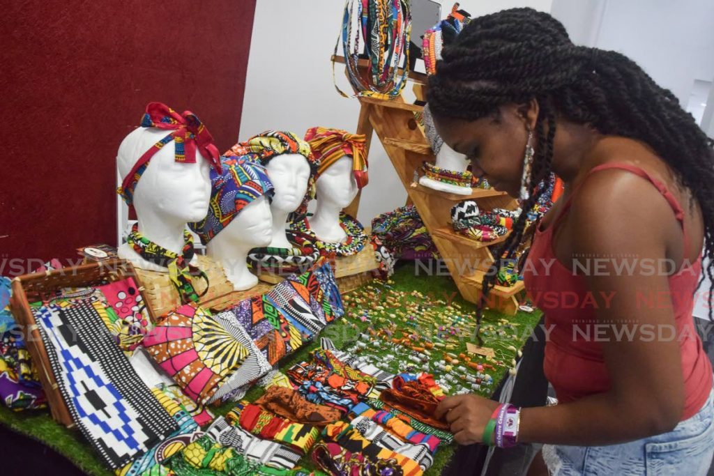 Anokye Blissett, a visitor from New York, looks at some of the accessories on display at Culture BandTT’s booth, at Soaka’s Carnival UpMarket on Saturday.  - Vidya Thurab