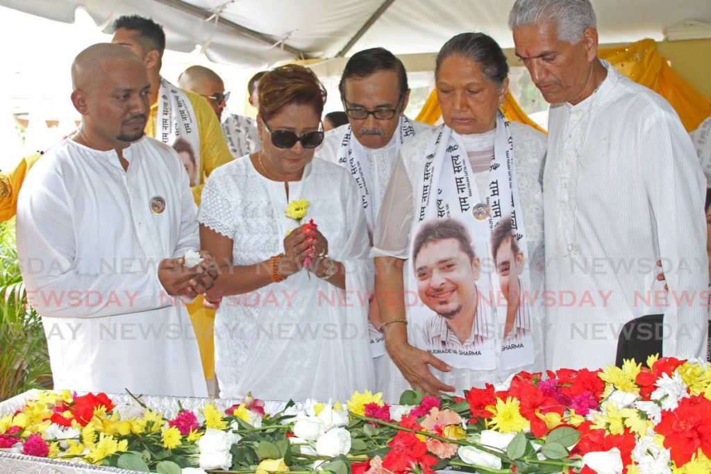 SAYING GOODBYE: Dr Prem Naidoo, left, who survived an attempted kidnapping in which his friend Dr Rudradeva Sharma was killed, says his goodbyes at Sharma's funeral on Sunday. Also paying respects were Opposition Leader Kamla Persad-Bissessar, Sharma's mother Mayoree and his uncle Karmesh. Photo by Marvin Hamilton - Marvin Hamilton