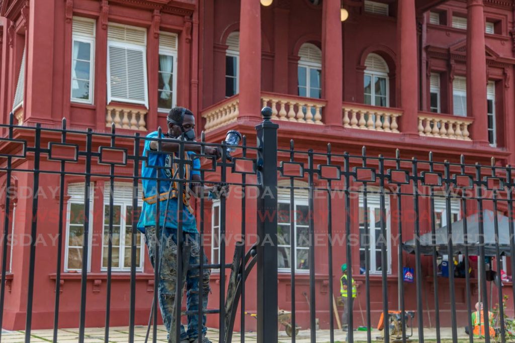 FINAL TOUCHES: A worker paints the fence surrounding the Red House ahead of its re-opening on Friday.  PHOTO BY JEFF K MAYERS - Jeff Mayers