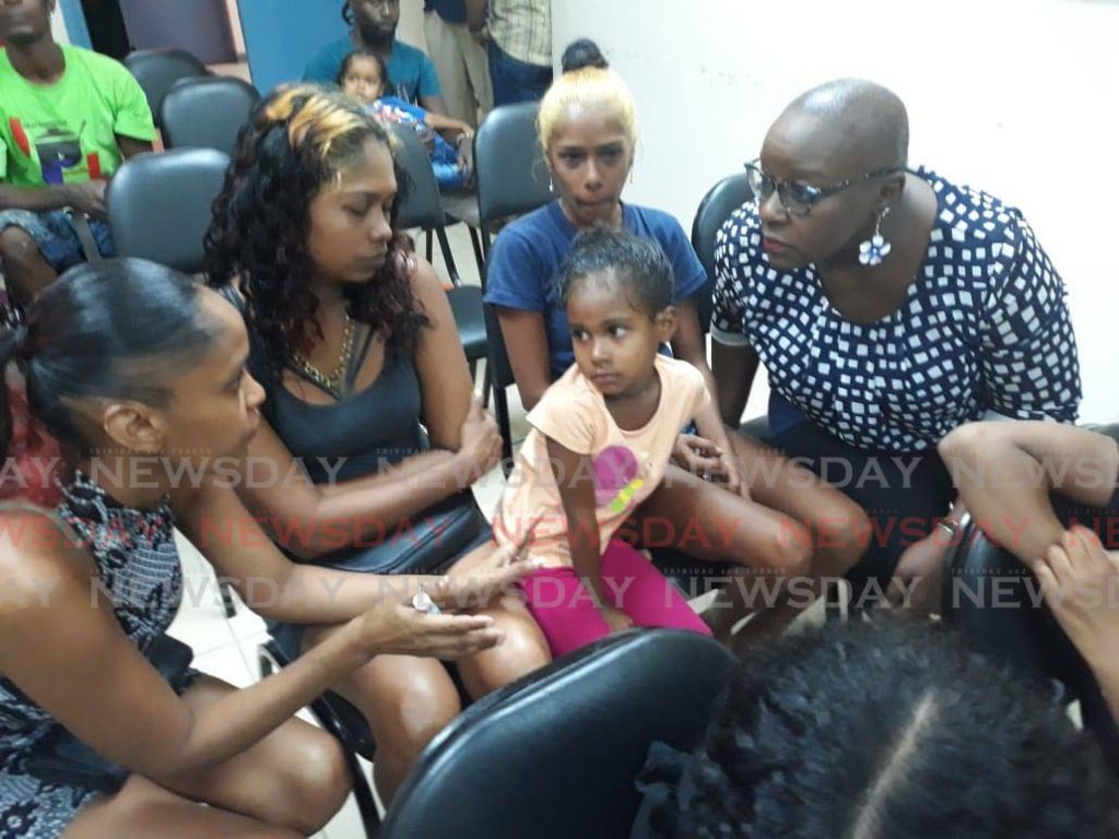 Minister of Social Development and Family Services Camille Robinson-Regis speaks to some of the people who were left homeless after fire razed several homes at Beetham Gardens, Port of Spain, on Friday. - 