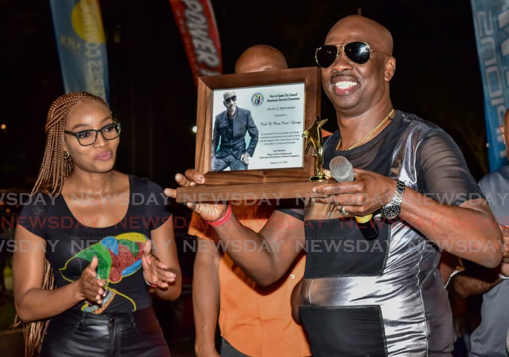 Neil 'Iwer' George displays an award presented to him by the Port of Spain City Corporation at the launch of Downtown Carnival hosted by the Port of Spain City Corporation at Woodford Square, on Friday. PHOTO BY JEFF MAYERS - Jeff Mayers