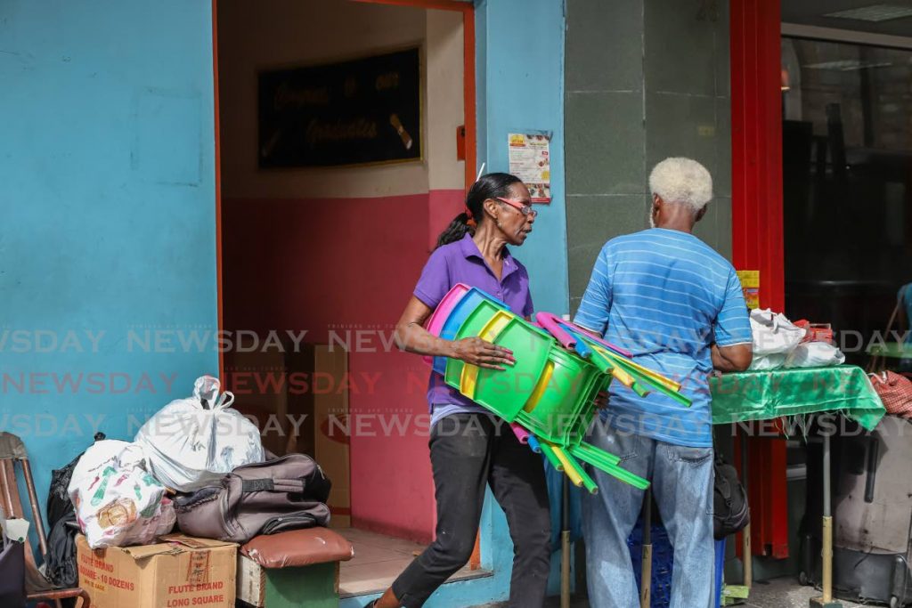 Parents assist employees of the landlord as they pack items from  Babys'Preschool on Independence Square, Port of Spain, onto a truck on Wednesday.  - JEFF K MAYERS