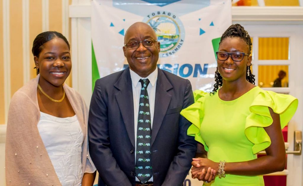 Chief Secretary Kelvin Charles, centre, with national scholarship winners Sharese Taylor, right, and Anique Gray at a ceremony honouring the island's top CAPE, CSEC students.  - THA