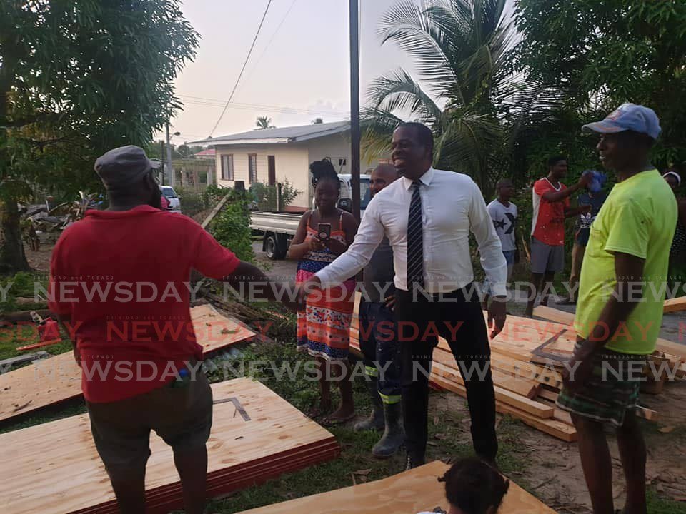 MP Dr Lovell Francis greets a man at the site where a fire burnt down a house on Thursday. - Dr Lovell Francis' Facebook page