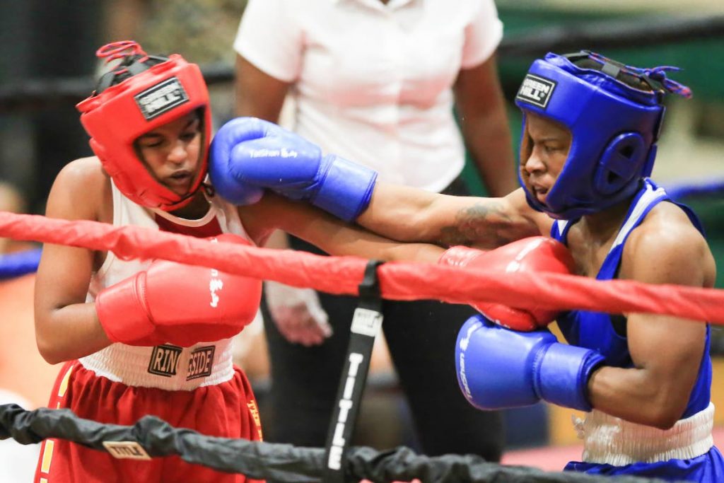 Jewel Lambert of Golden Fist Gym (blue shorts) and TT’s Faith Ramnanth of Faith Boxing Club (red shorts) in action during the Spanish Invasion Boxing Championships , at the Plesantville Indoor Sports Arena, on Saturday. - Allan V. Crane/CA-images