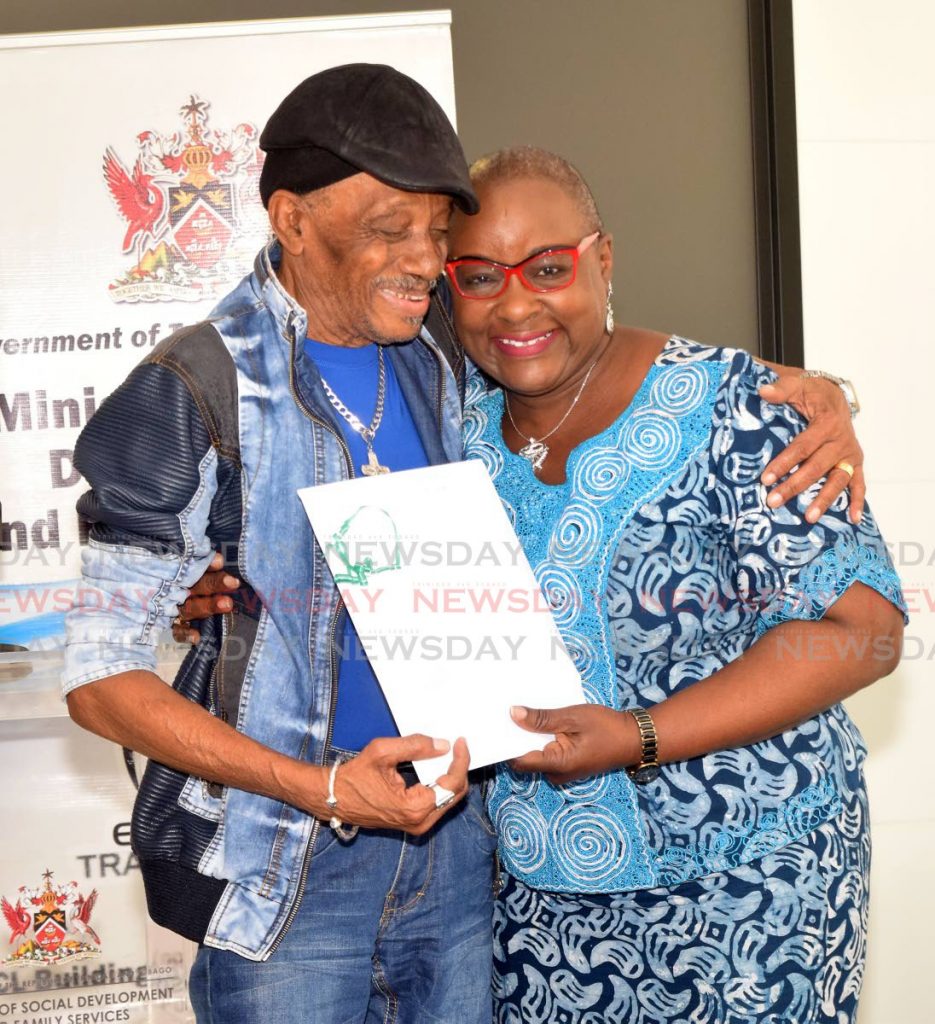 MINISTER & THE BARON: Social Development Minister Camille Robinson-Regis hugs calypso veteran Timothy “The Baron” Watkins on Monday after presenting him with a Special Achievors monthly grant at the ministry’s office. 
 - Vidya Thurab