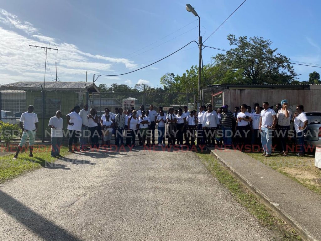 Students of the Point Fortin East Secondary School and their parents line up in front the school's gate on Tuesday as they were told the school was shut down until further notice and no one could enter. Photo by Narissa Fraser