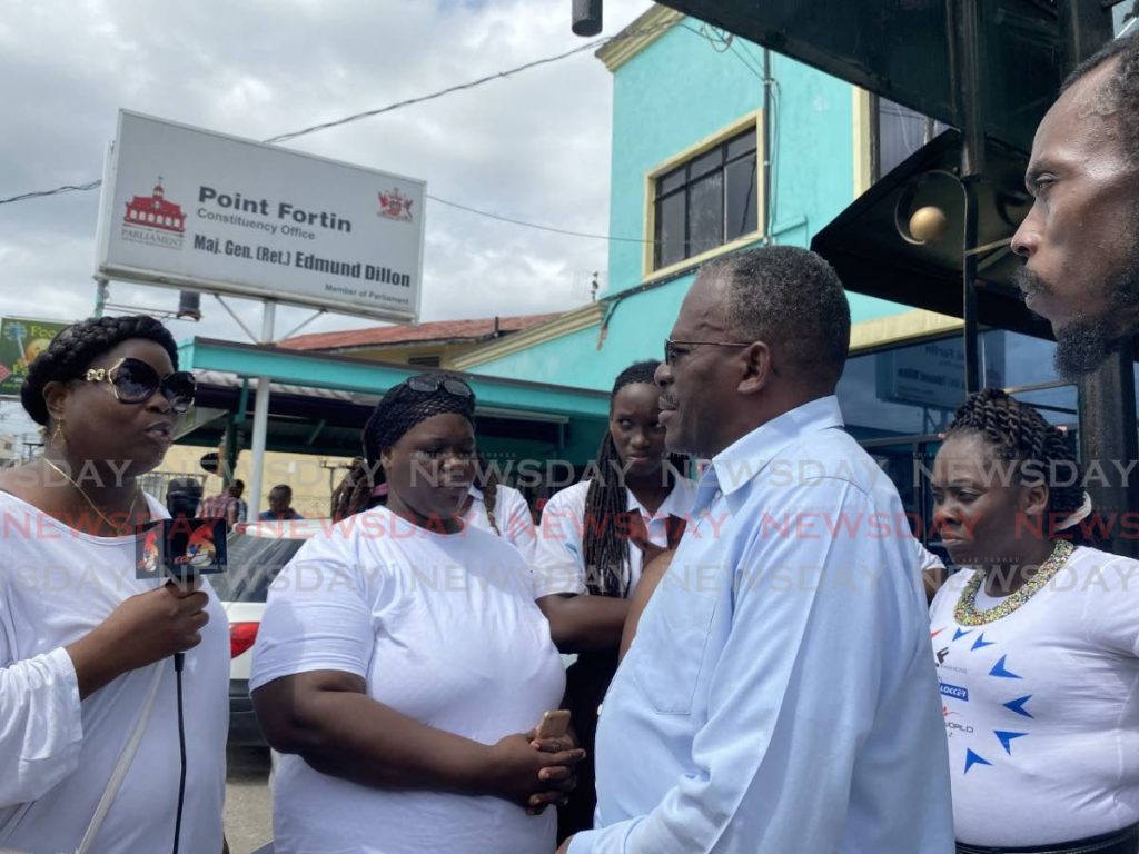 Parent Luel Boatswain engages Point Fortin MP Edmund Dillon outside his office on Tuesday.  - Narissa Fraser