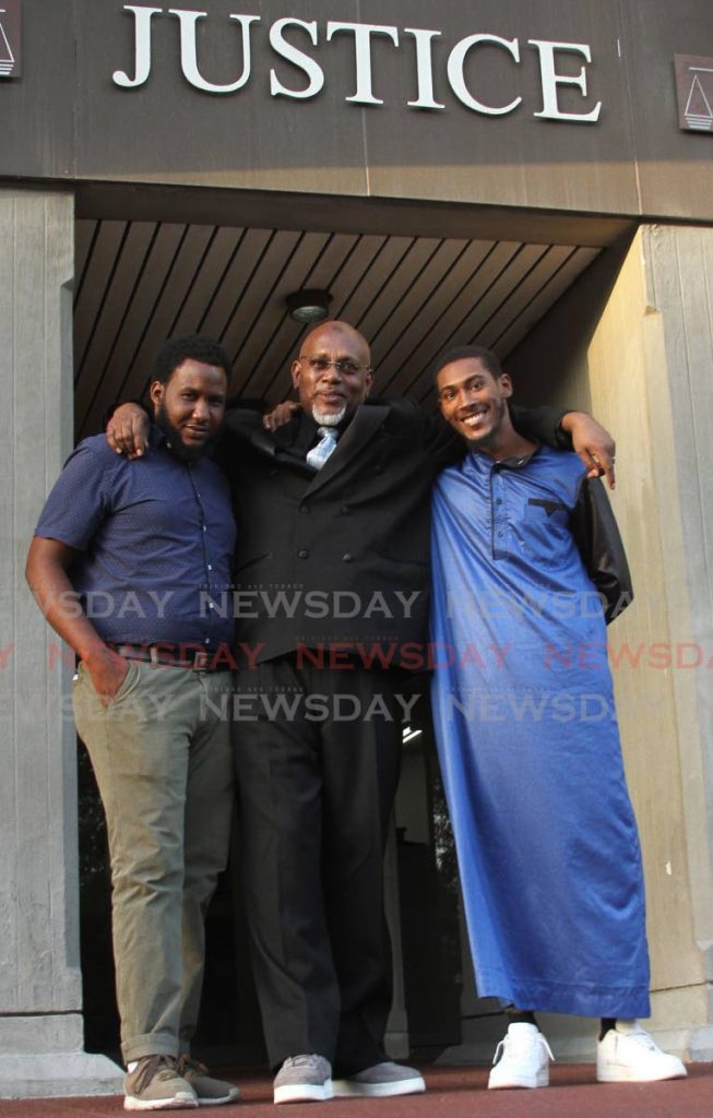 FREE MAN: Sheldon Reid (centre) poses for a photo with his sons Fareed, left, and Jamile at the Hall of Justice on Thursday. PHOTO BY AYANNA KINSALE  - Ayanna Kinsale