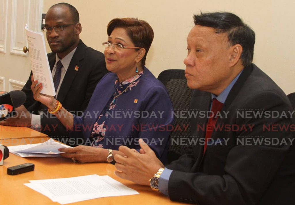 Opposition Leader Kamla Persad-Bissessar is flanked by UNC senator Taharqa Obika and Pointe-a-Pierre MP David Lee at a media conference in the Red House on Friday.  PHOTO BY AYANNA KINSALE - Ayanna Kinsale