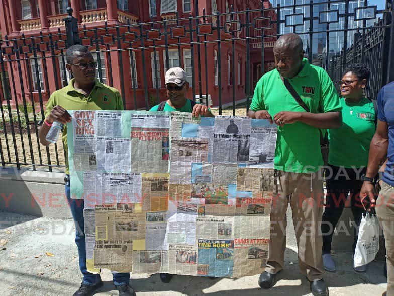 Members of the Public Services Association and the National Trade Union Centre pose with a poster made up of news clippings involving the Public Transport Service Corporation during a demonstration in Port of Spain on Monday. - Andrew Gioannetti