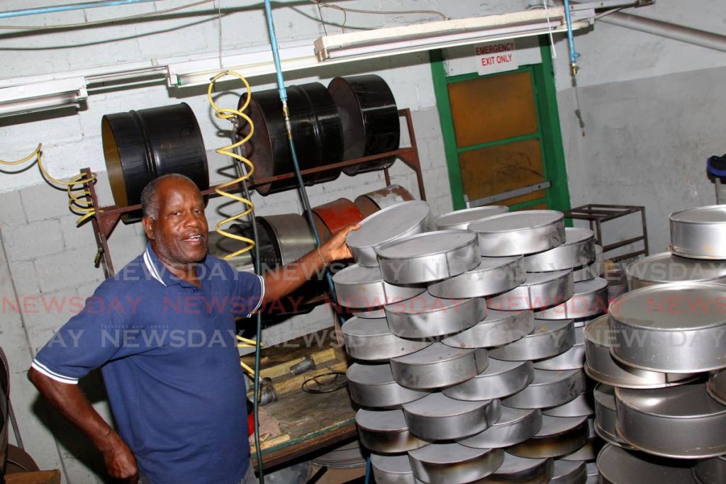 Panland president Michael Cooper highlights the miniature steelpans which the company manufacturers at its factory, Eastern Main Road, Laventille. - ROGER JACOB