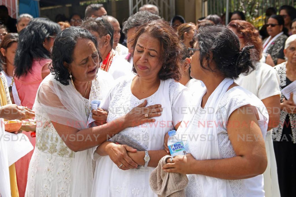 Relatives comfort Tara Singh as she weeps during the funeral for her murdered son Charan at Chickland, Freeport on Saturday. Charan died of gunshot wounds during an attack on February 12. - Marvin Hamilton