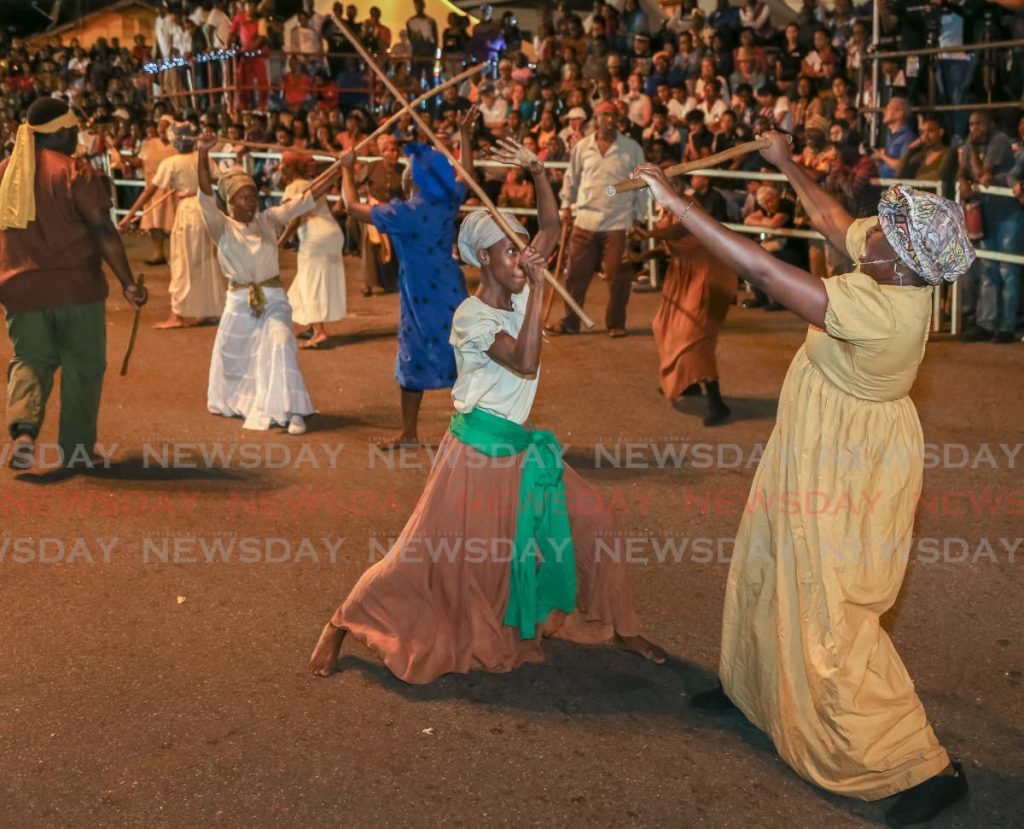 Two women do battle during the re-enactment of the Canboulay riots at Piccadilly Greens in Port of Spain.  PHOTO BY JEFF K MAYERS - 