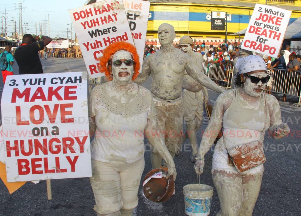 These mud mas revellers came with their placards as well.  - ROGER JACOB