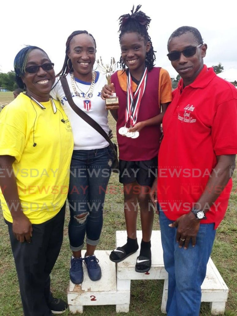 La Brea RC athlete, Chelcia Joseph (second from right), shows off her Girls U-11 Victrix trohpy and four gold medals (long jump, 100m, 200 and 4x100m relay) at her zone's Primary Schools' Track and Field Championships at Sobo Recreation Ground on February 14. She is joined by (left to right) La Brea RC teacher Sharnol Smith-Small, mother Mitchelle Joseph and principal Leon Charles.   - Chequana Wheeler