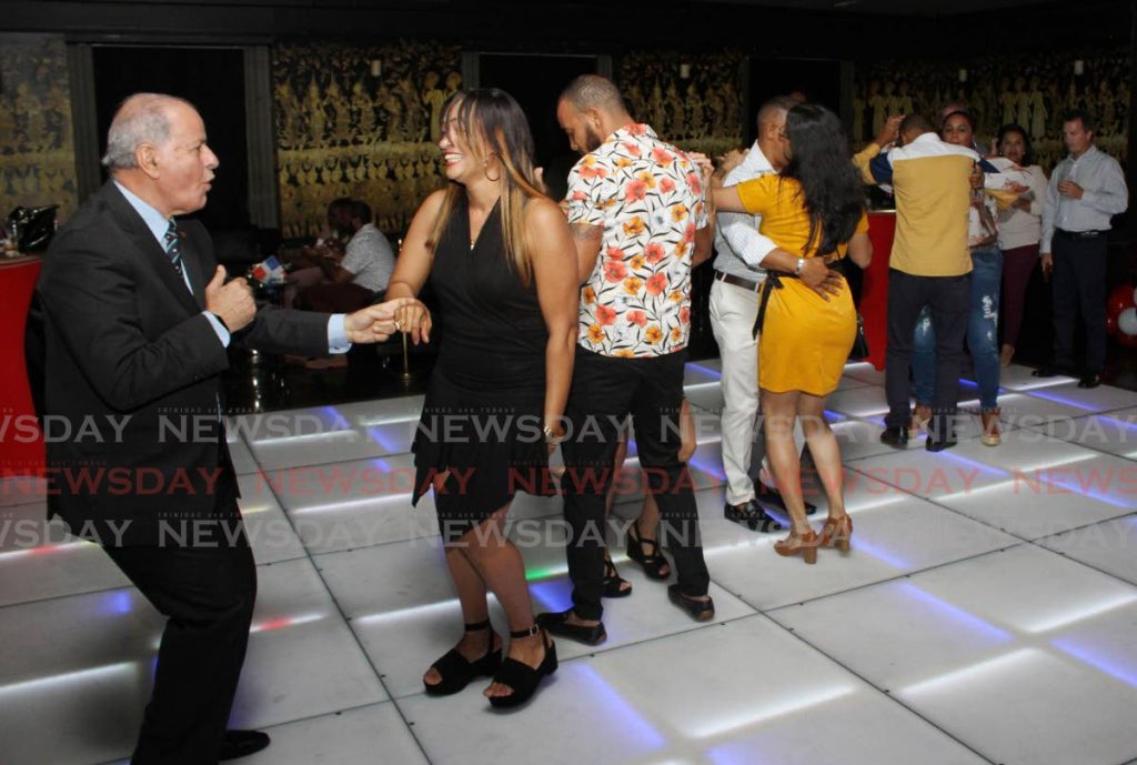 Dominican Republic Ambassador to TT Dr Jose Serulle, left, dances with a friend. - Angelo Marcelle