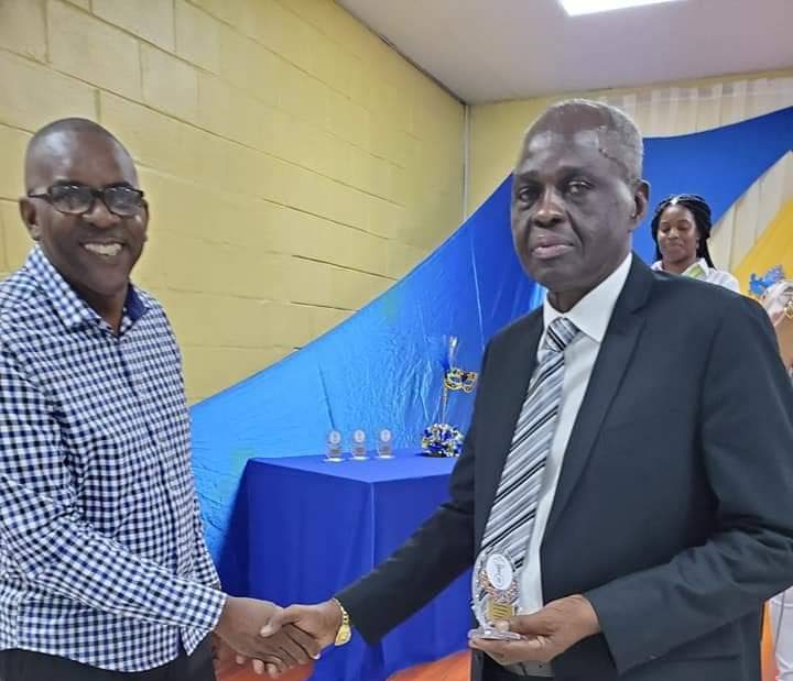 Former chief fire officer Roosevelt Bruce congratulates former deputy commissioner of police Glen Roach who was awarded for his contribution to the Chinapoo community in Morvant.
 - 