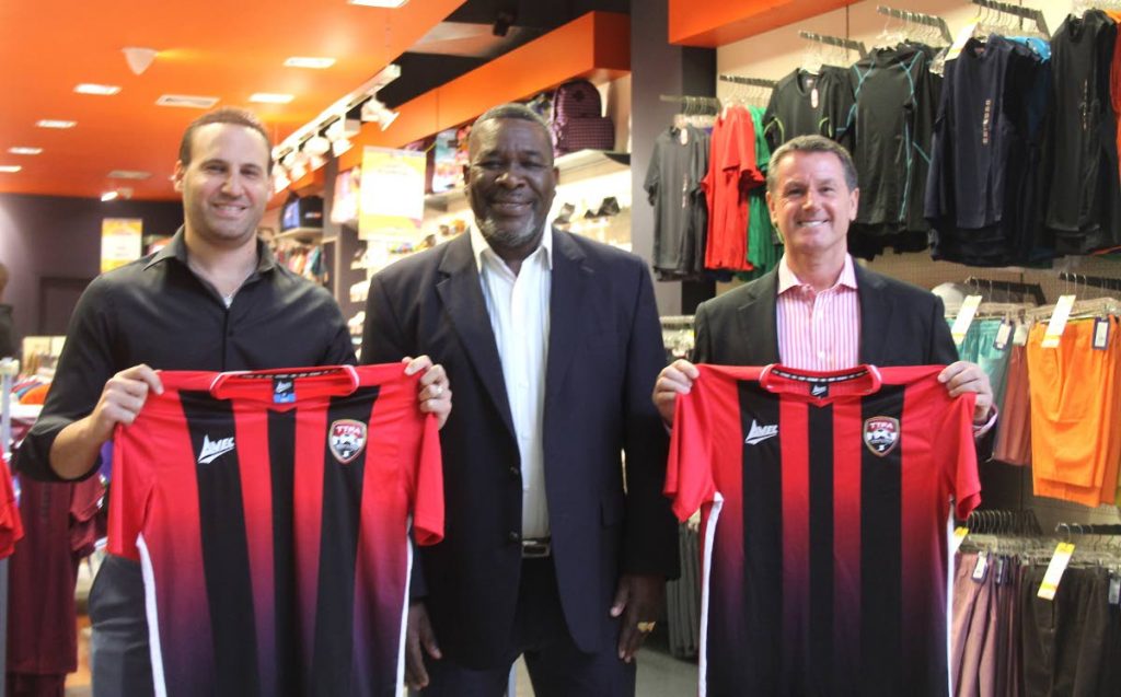 TTFA president William Wallace (centre) along with Omar Hadeed, director of Sports and Games Limited (left) and TT men’s football team coach Terry Fenwick, after the finalisation of a four-year deal, at Sports and Games Trincity Mall outlet, on Monday. PHOTO COURTESY TTFA - 
