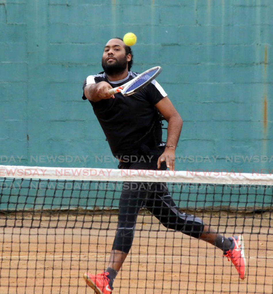 Richard Chung makes a return against the pair of Jamal Alexis and Tyler Hart, during the men’s doubles quarter-final, of the Shell Tranquillity tennis tournament, at the Tranquillity Courts, Victoria Avenue, on Monday. Chung played alongside team-mate Dexter Mahase. - Sureash Cholai