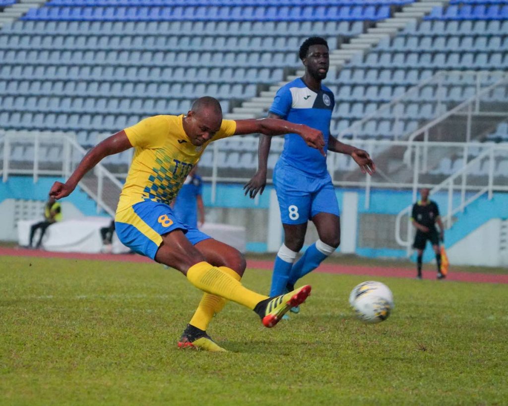 Defence Force Brent Sam, left, hits a shot at goal during the TT Pro League match between Defence Force and Police FC at Ato Boldon Stadium, Couva, on Sunday. Sam scored two goals to see Defence Force FC get passed Police FC 4-1. - Daniel Prentice/CA-images