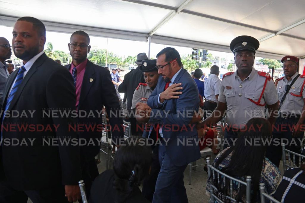 Minister of National Security Stuart Young is escorted to an ambulance by fire officers and ministry officials after he fell at the opening of the Penal Fire Station on Tuesday morning. - Marvin Hamilton