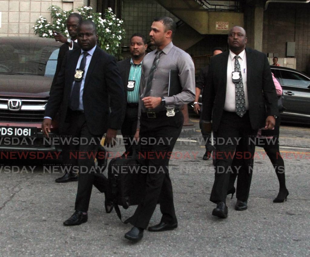 Police officers leave Express House on Independence Square, Port of Spain after conducting a search. - Ayanna Kinsale