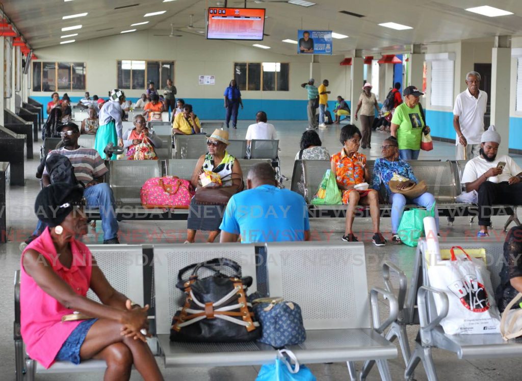 Commuters sit and wait at the PTSC terminal at South Quay, Port of Spain, as drivers hold a meeting about their covid19 concerns on Friday. - ROGER JACOB