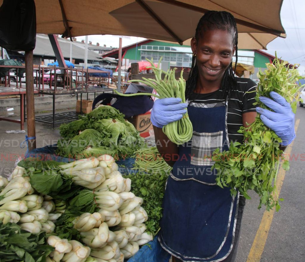 Market vendor Stacy Jules  wore gloves as she sold her produce at the Central Market in Port of Spain on Saturday.  - Sureash Cholai