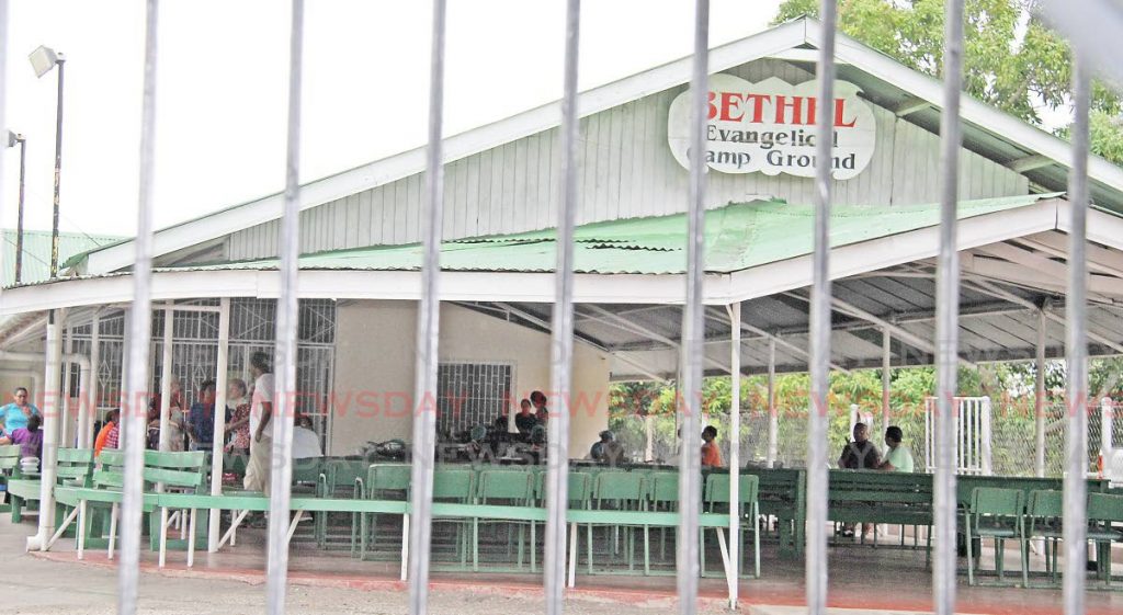 People mingle at the Bethel Evangelical Camp Ground in Freeport on Saturday. The car park and recreational facility is opposite The Bethel House of God church. - Vashti Singh