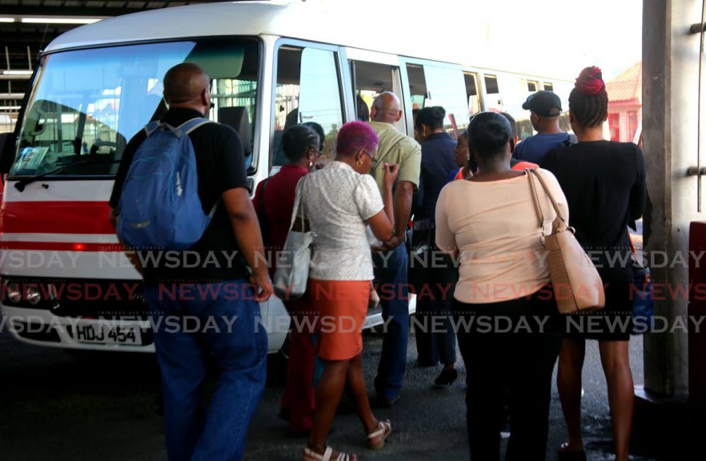 Commuters board a maxi taxi in City Gate in Port of Spain on Wednesday. Most maxis were not leaving the terminal until all seats were filled. - SUREASH CHOLAI