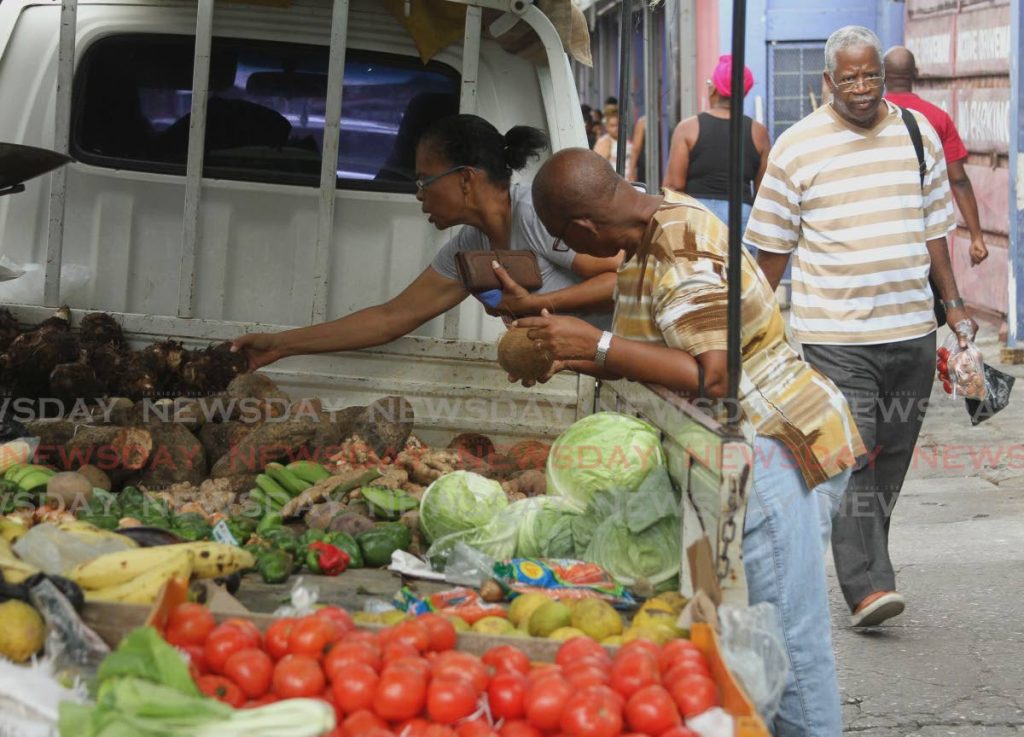Customers buy provisions along Charlotte Street, Port of Spain on Saturday. - Ayanna Kinsale