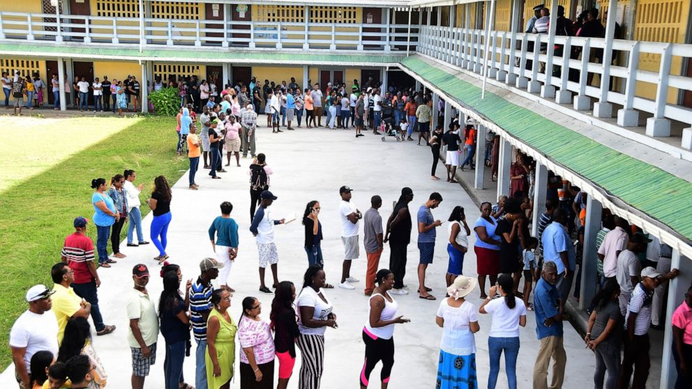 People line up to vote during presidential elections in Georgetown, Guyana, on March 2. Police on Saturday confirmed a protester was shot dead as tensions escalate over a dispute on the election results. (AP Photo/Adrian Narine) - 