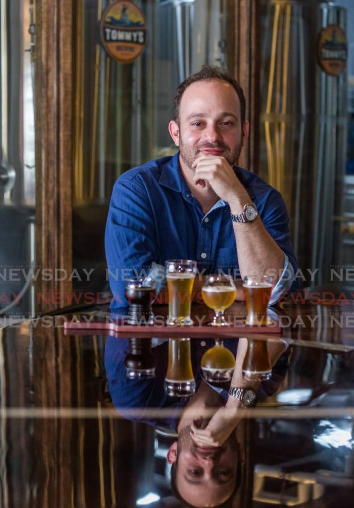 In this file photo, John Tannous, owner of Tommy's Brewing Company displays some of the beer options available at his micro-brewery and restaurant at Movietowne, Port of Spain. - Jeff K Mayers