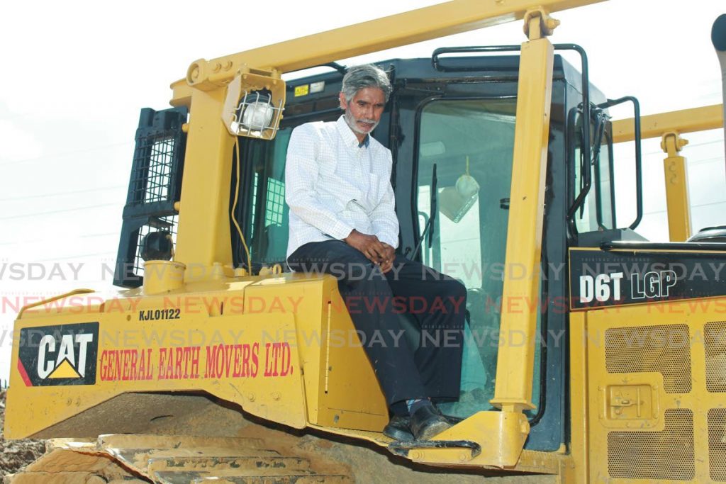 Dr Wayne Kublalsingh sits on a backhoe as he asks the driver to stop work that was being done at Sewlal Trace, Fyzabad on January 30.  - CHEQUANA WHEELER