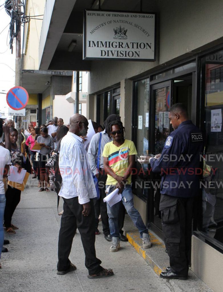 File photo - People wait outside the Immigration Division office on Frederick Street, Port of Spain. - 