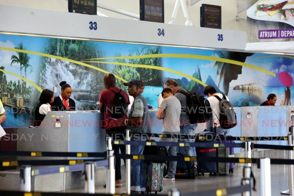 In this March 23 file photo passengers line up at the British Airways counter at Piarco International Airport for one of three repatriation flights to the UK. PHOTO BY SUREASH CHOLAI  - 